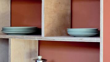 Une étagère en bois sur laquelle sont disposés divers objets en verre et en céramique.