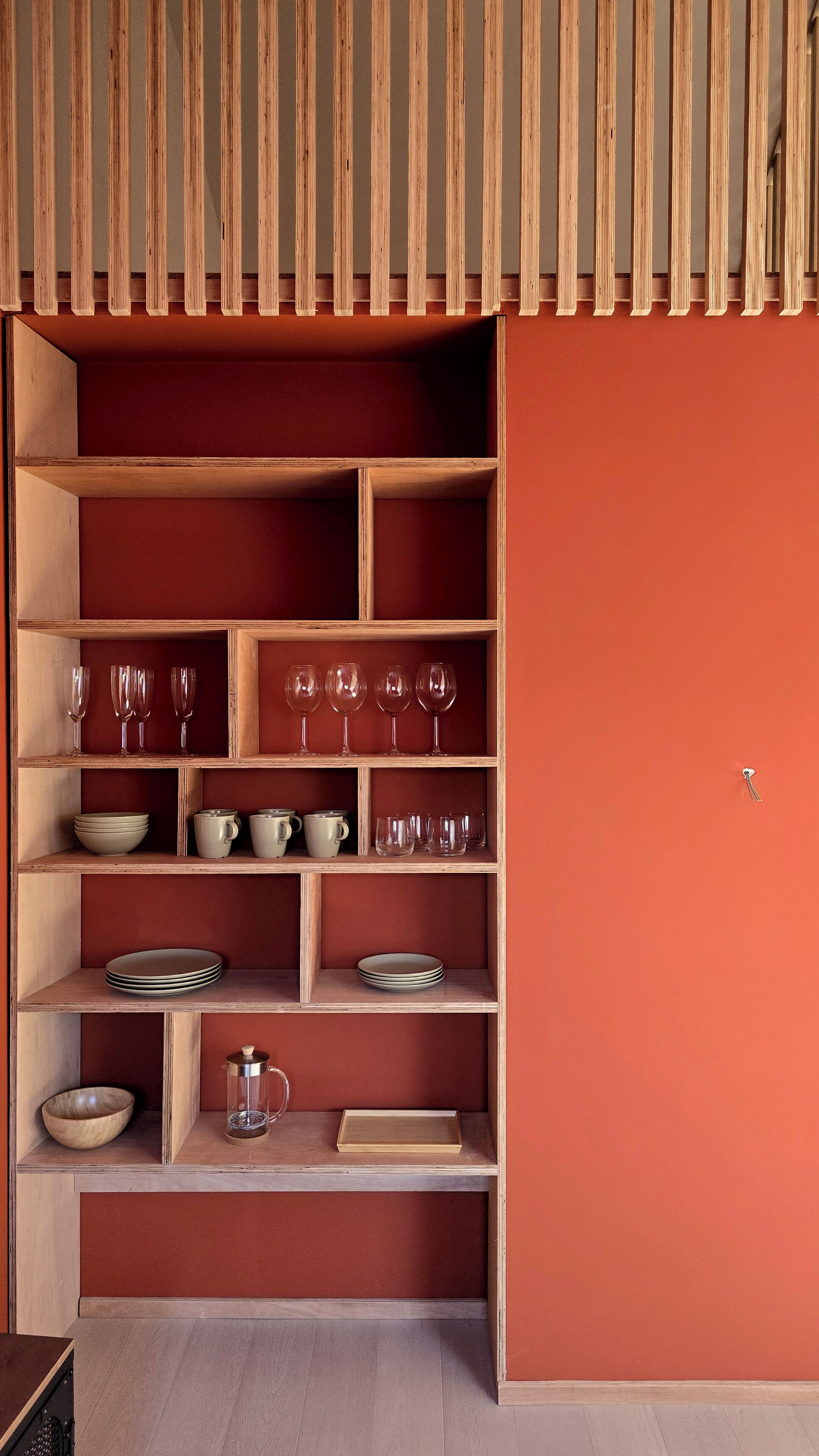 Une étagère en bois contenant divers ustensiles de cuisine et articles en verre.