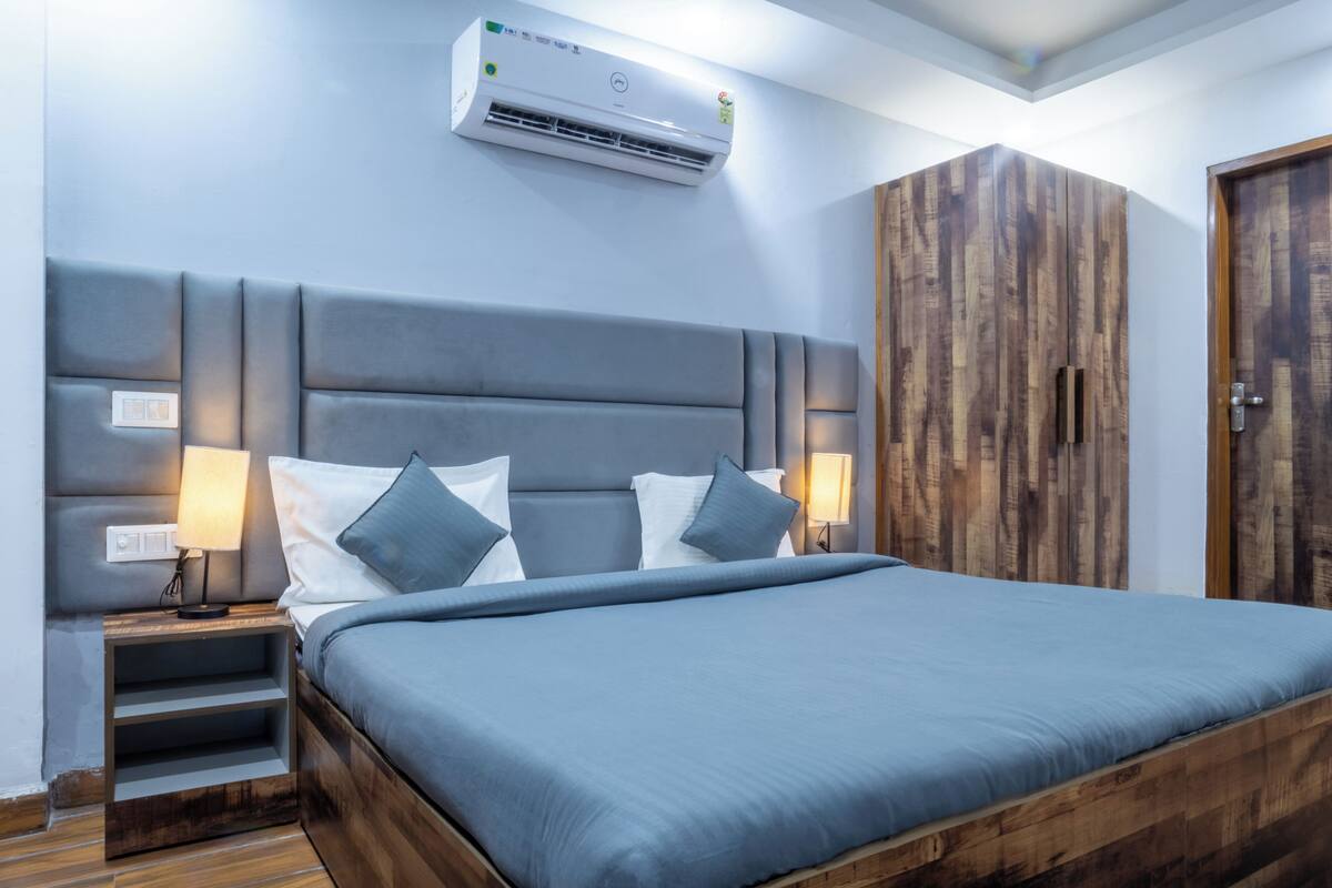 Ein Schlafzimmer mit einem großen Bett, einem Holzschrank und einer Klimaanlage.