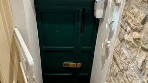 A staircase leading to a dark green door with a decorative glass window above it.
