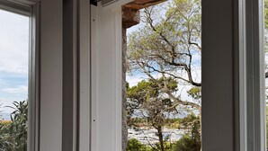 A view from a balcony with a stone wall and a railing.