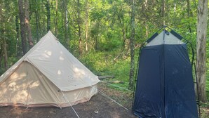 Two tents in a forest setting.
