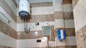 Une salle de bain avec des toilettes, un lavabo et une douche.