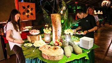 A buffet table with various food items and a decorative centerpiece.