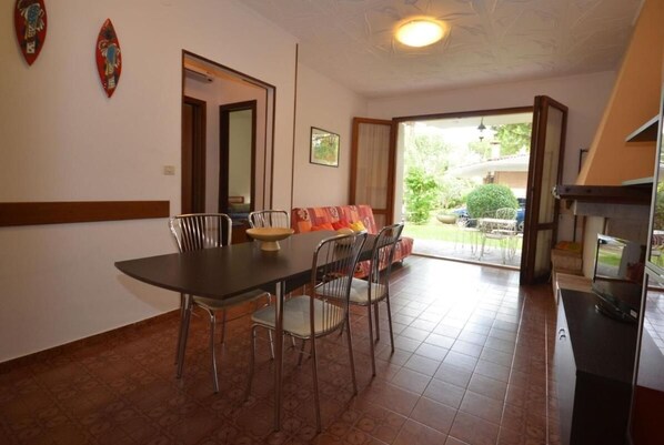 Un coin repas avec une table et des chaises, un canapé et un téléviseur.