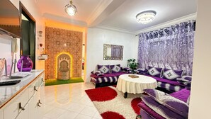 A living room with a sofa set, a coffee table, a patterned wall, and a decorative archway. - Large and beautiful app, large stad ibnoubatouta 15mm Tangier Airport (Tanger)
