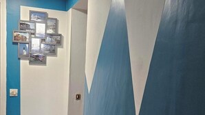 A hallway with blue and white walls, a light switch, and a door. - House "Chez Simone" Le Tréport Walks or bike rides Pets welcome! (Le Tréport)