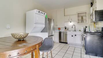 A kitchen with white cabinets, a stainless steel refrigerator, a built-in oven, and a microwave.