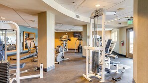Ein Fitnessstudio mit verschiedenen Trainingsgeräten, darunter Laufbänder, Ergometer und Kraftgeräte.