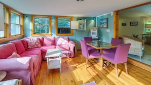 A cozy room with a pink sofa, a glass table, and purple chairs. - 13 Mi to Acadia: Artistic Retreat in Nature (Trenton)