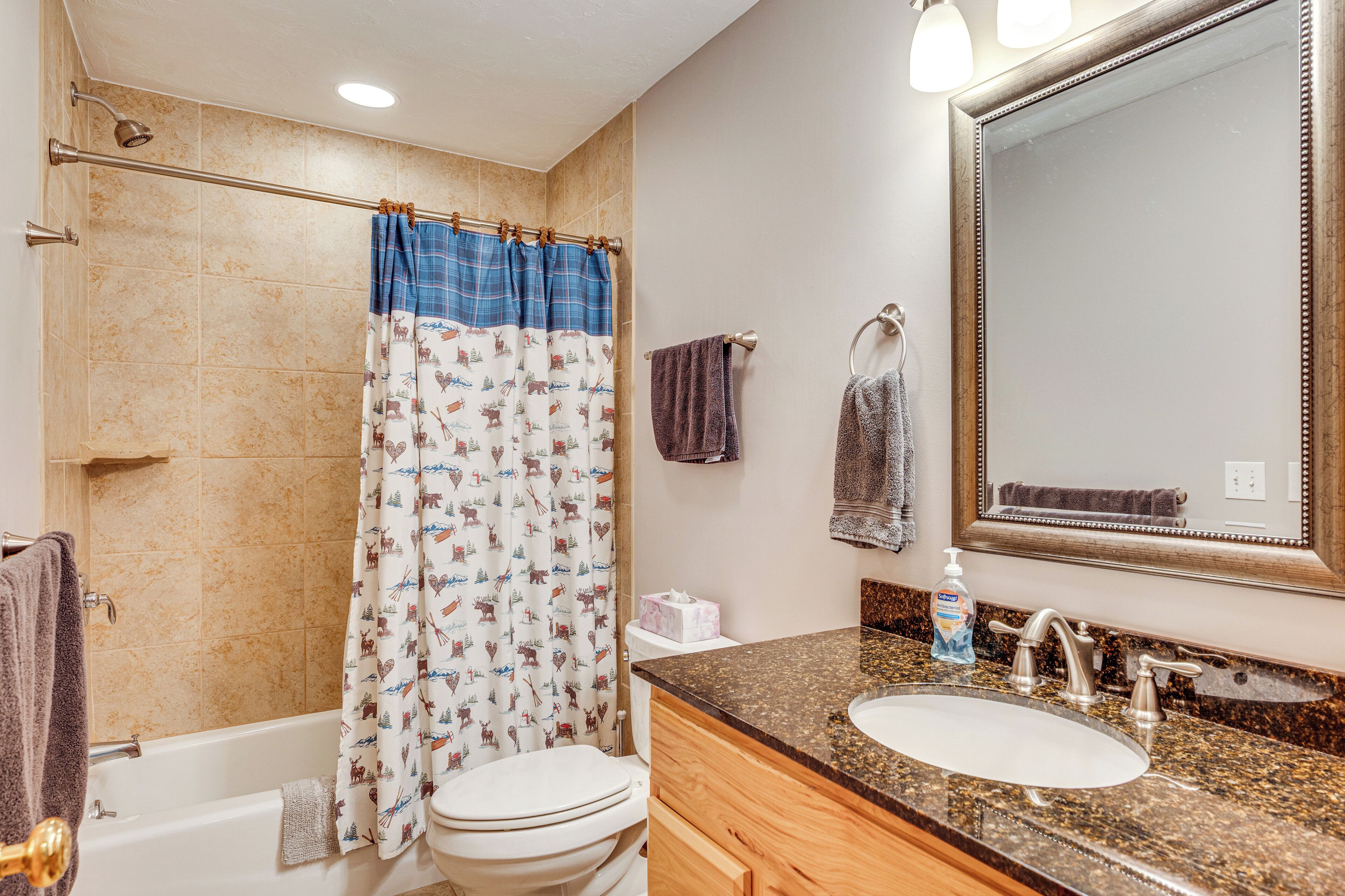 Une salle de bain avec une baignoire, des toilettes, un lavabo et un grand miroir.