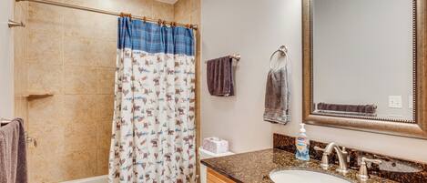 Une salle de bain avec une baignoire, des toilettes, un lavabo et un grand miroir.