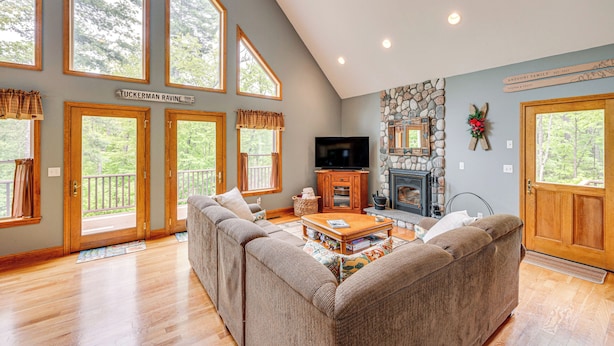 A spacious living room with a large sectional sofa, a fireplace, and a stone accent wall. - Ski, Hike & Fish: Chalet w/ Hot Tub in Conway (North Conway)