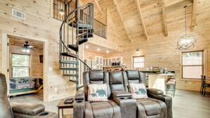 A spacious wooden cabin with a cozy living area featuring leather recliners and a spiral staircase. - Sip, Hike & Explore: Sleek Retreat in Cleveland! (Cleveland)
