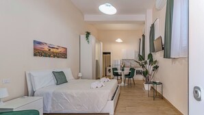 Una habitación de hotel moderna con cama, mesita de noche y vistas al pasillo.