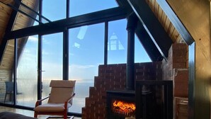 A loft-style room with a large skylight, a brick fireplace, and a cozy seating area. - Ordu Bungalov Loın Du Monde (Persembe)