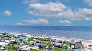 Une zone résidentielle côtière avec des maisons, une plage et l’océan.