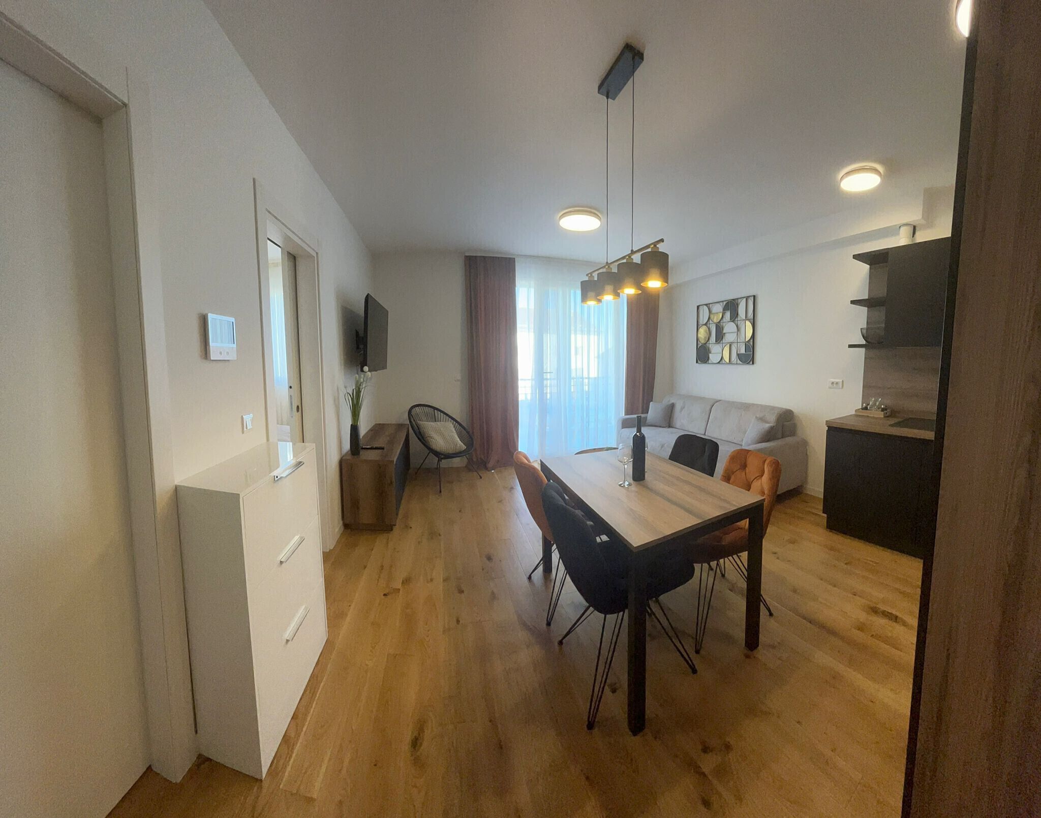 Un appartement moderne comprenant un coin repas, un canapé, une télévision et une cuisine.
