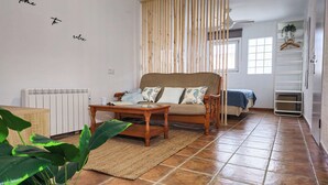 A cozy living room with a sofa, a wooden coffee table, and a radiator.