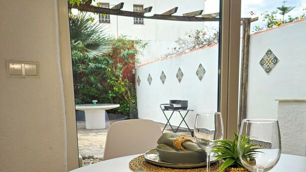 A dining table with a woven placemat, a bowl with a napkin, and a glass of water.