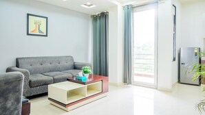 Una sala de estar moderna con un sofá gris, una mesa de centro blanca y una obra de arte enmarcada en la pared.