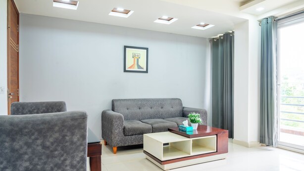 A modern living room with a grey sofa, a matching armchair, and a wooden coffee table.