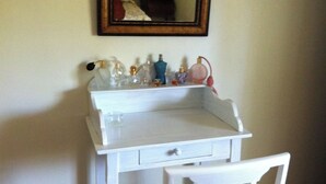 A small white desk with a mirror above it, a chair with a cushion, and various toiletries on the desk. - Village house sleeps 6 near ST CROIX DU VERDON (Roumoules)