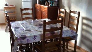 A dining table with chairs, a refrigerator, a wooden cabinet, and a window. - Village house sleeps 6 near ST CROIX DU VERDON (Roumoules)