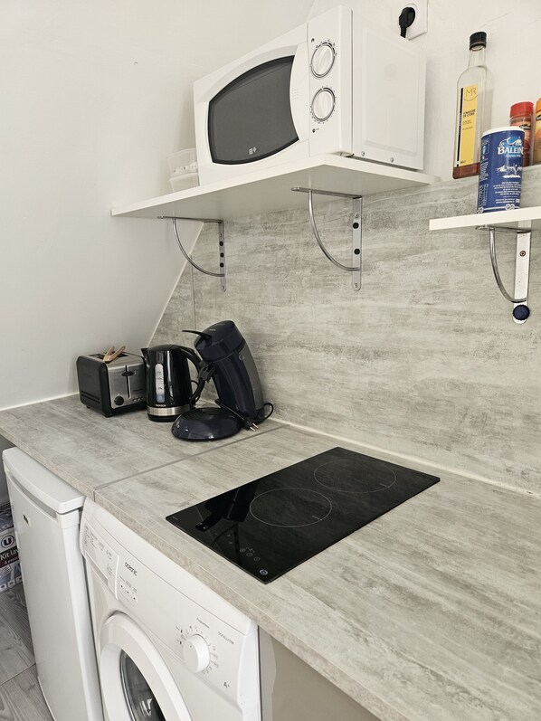 A compact kitchen with a microwave, toaster, coffee maker, and a built-in stove. - Studio in the center of SAUJON (Saujon)