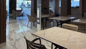 Een moderne eetruimte met marmeren vloeren, modern meubilair en inbouwspots.
