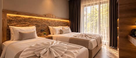 A modern hotel room with two beds, a brick-patterned headboard, a large window with sheer curtains, and a wooden floor.