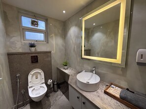 A modern bathroom with a toilet, sink, and mirror. - Housr Sector 42 Gurgaon Golf Course Road (Gurugram)