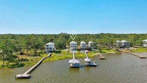 A lakeside property with multiple buildings, docked boats, and a well-maintained grassy area.