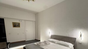 A bedroom with a bed, bedside tables, a desk, and a wardrobe. - The better (San Giorgio a Cremano)