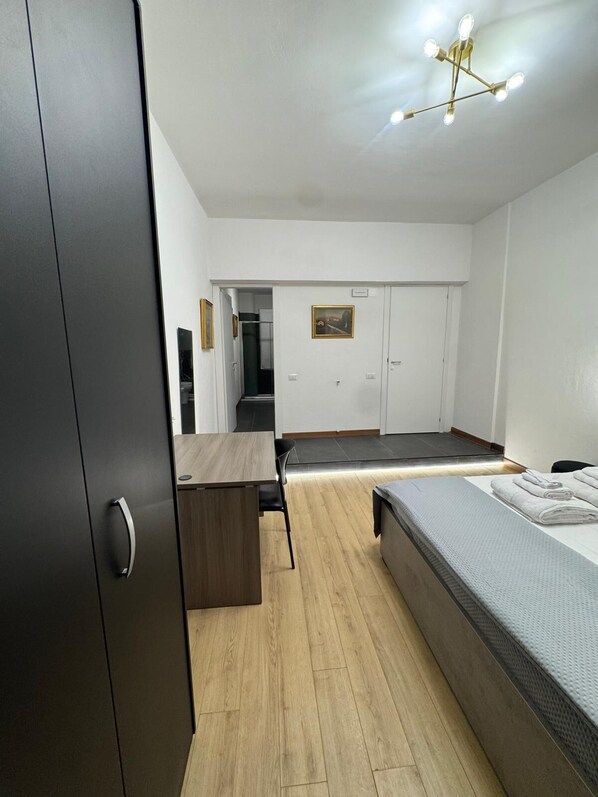 A modern bedroom with a bed, a desk, and a wardrobe. - The better (San Giorgio a Cremano)