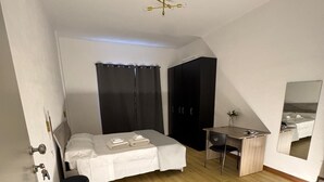 A modern bedroom with a bed, a desk, a wardrobe, and a ceiling fan. - The better (San Giorgio a Cremano)