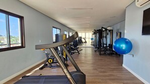 Une salle de sport équipée de matériel d’exercice, d’un tapis de course et d’un grand ballon bleu pour faire de l’exercice.