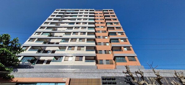 Un edificio alto con varios pisos, ventanas grandes y balcones.