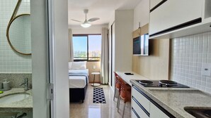 Une chambre d’h ôtel moderne dotée d’une salle de bain, d’une kitchenette et d’un lit avec vue.