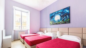 A hotel room with three beds, a large window, and a painting on the wall.