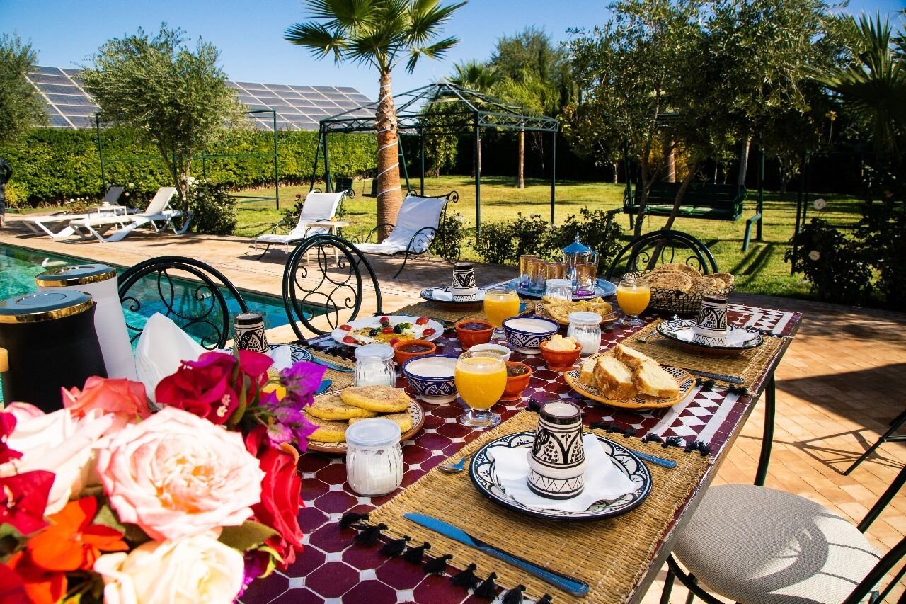 An outdoor dining area with a pool, lounge chairs, and a pergola.