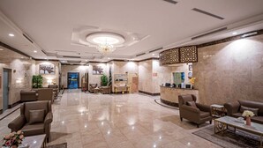 A spacious lobby with a reception desk, comfortable seating, and a chandelier. - Hotel Ajnihat Safwa Taiba (Madinah)