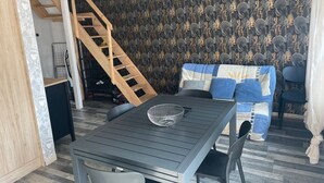 En matplats med ett bord och stolar, en trappa och en vägg med ett mönster.