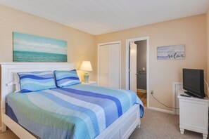 A bedroom with a bed, a nightstand, a television, and a painting on the wall. - OceanFront 8 Bedroom! (South Bethany)