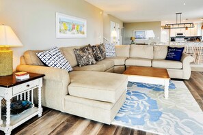 A living room with a sectional sofa, a coffee table, and a rug.