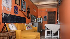 Una sala acogedora con un sofá amarillo, una mesita y un mueble de madera.