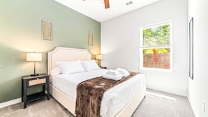 A bedroom with a bed, bedside tables, a window, and artwork on the walls. - Historic DT, Private, 30 Min to Dal | TSA (Rockwall)