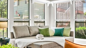 Ein gemütlicher Sitzbereich mit einer Couch, Kissen und einer Decke.