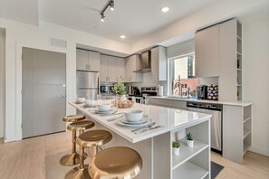 A modern kitchen with a central island, stainless steel appliances, and a minimalist design.