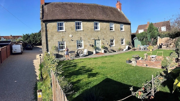 Une maison à deux étages avec une pelouse bien entretenue et un petit jardin.